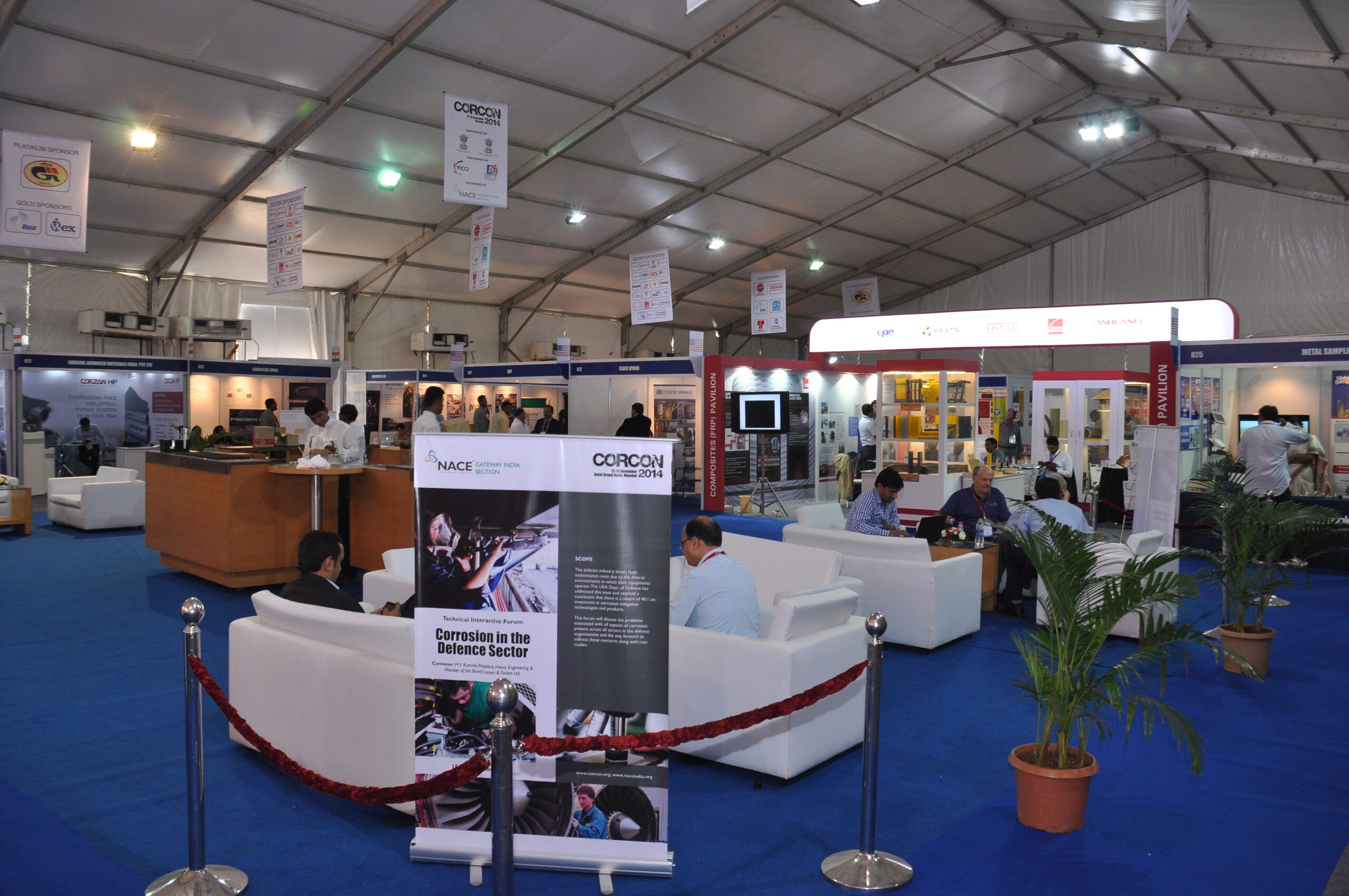 Corrosion and protective coatings industry exhibition showcasing technical booths, sponsor displays, and networking areas inside a large event pavilion.