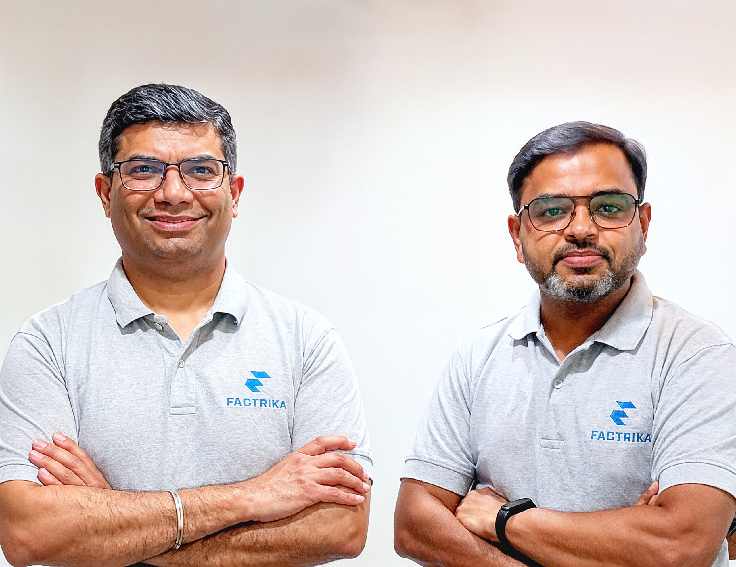 Two professionals wearing Factrika-branded polo shirts standing side by side with their arms crossed.